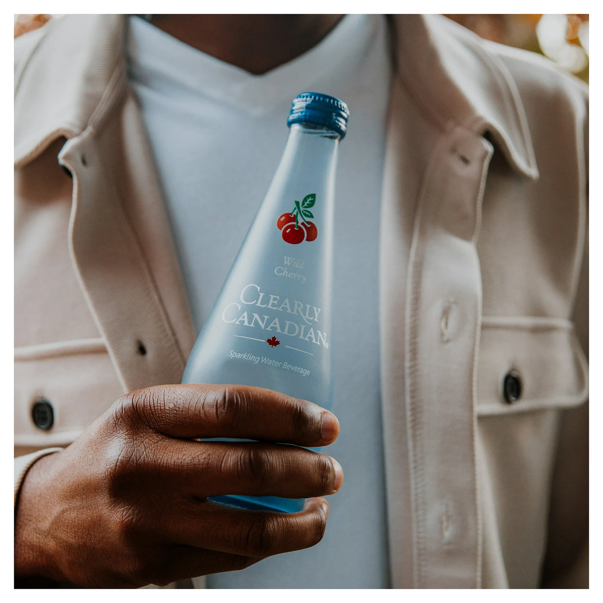 Person holding a 'Clearly Canadian' bottle with a blurred background