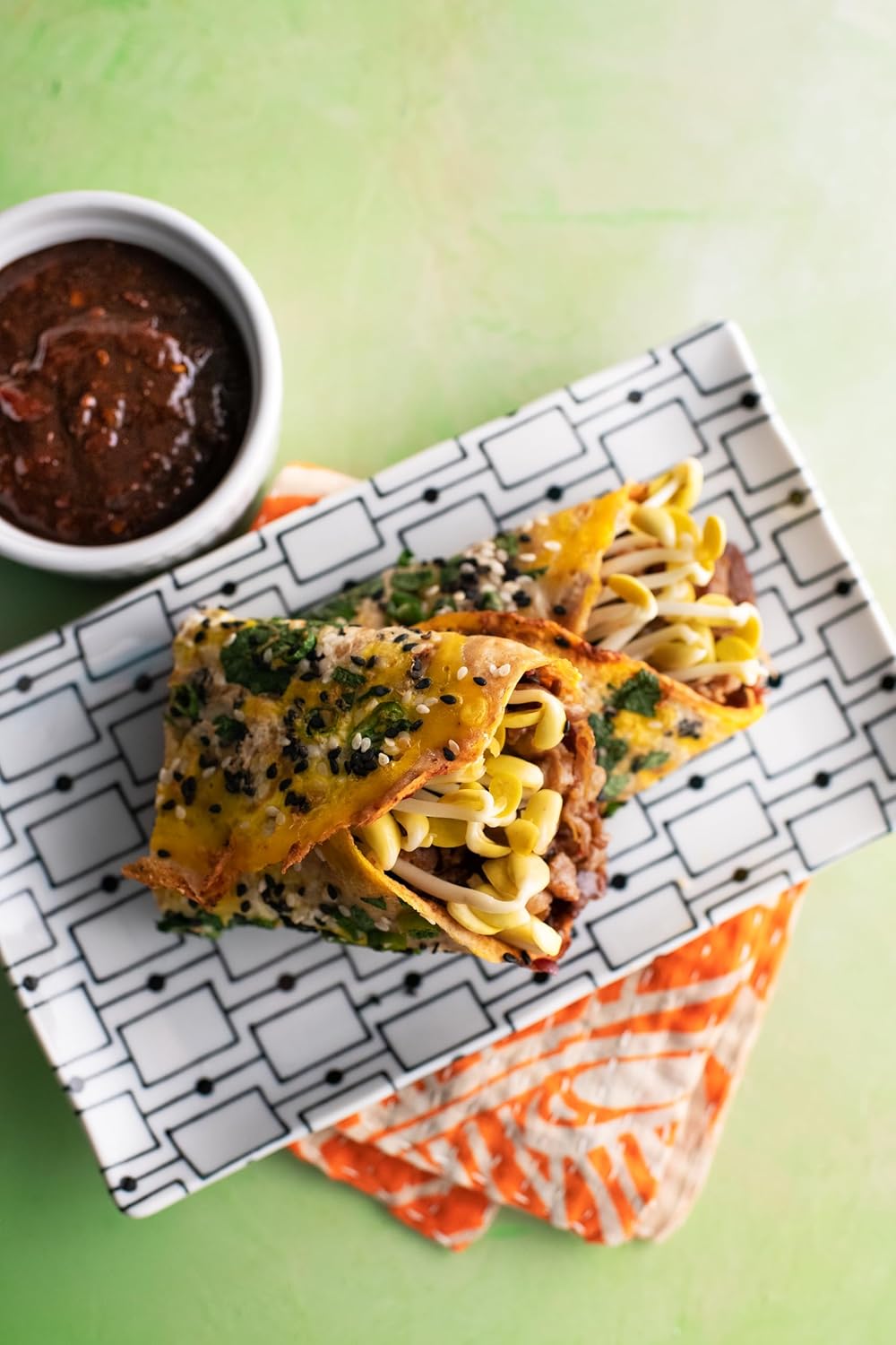 Pasta dish with a side of sauce on a patterned napkin