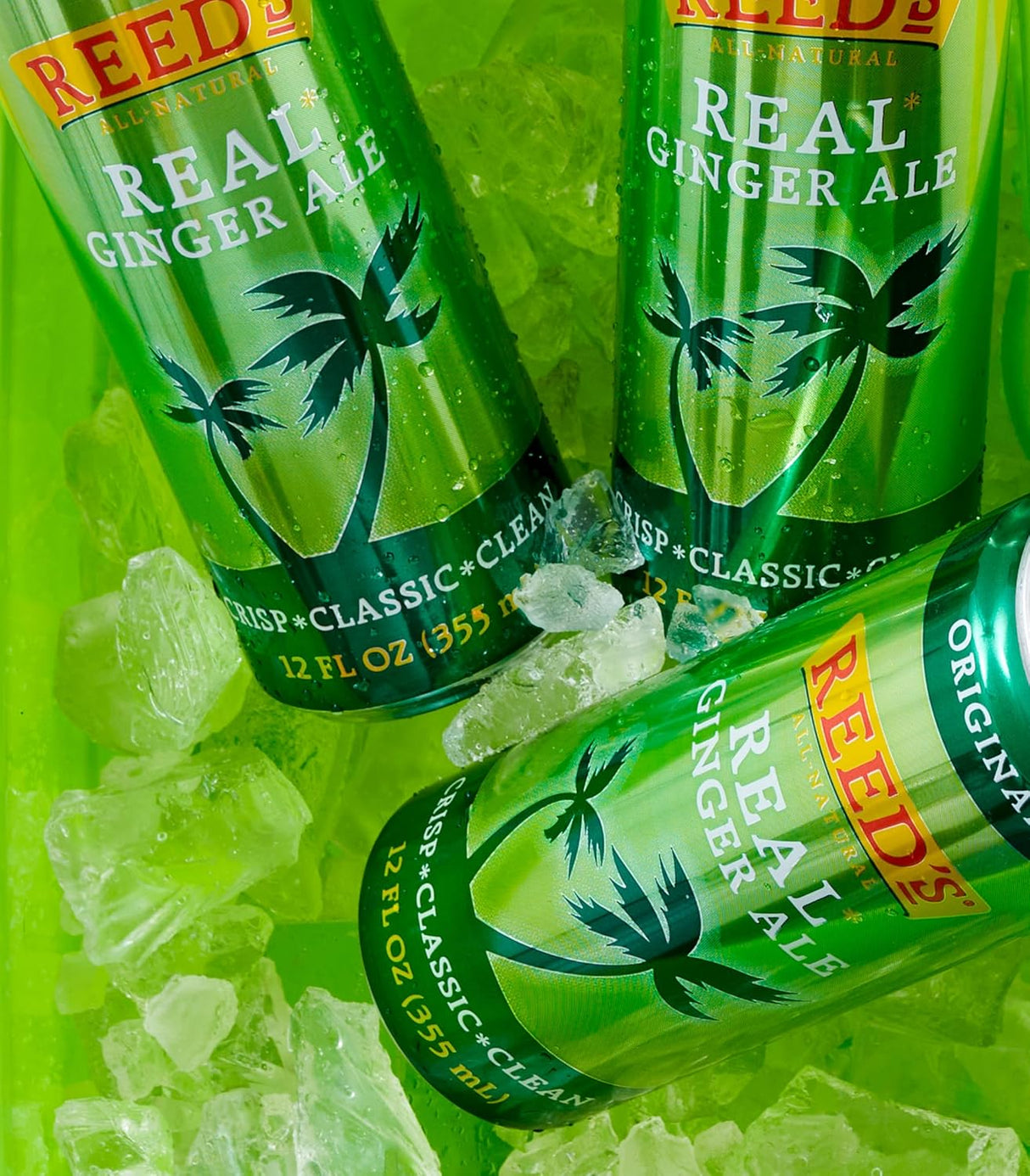 Three bottles of Reed's Real Ginger Ale on a green background with ice cubes.