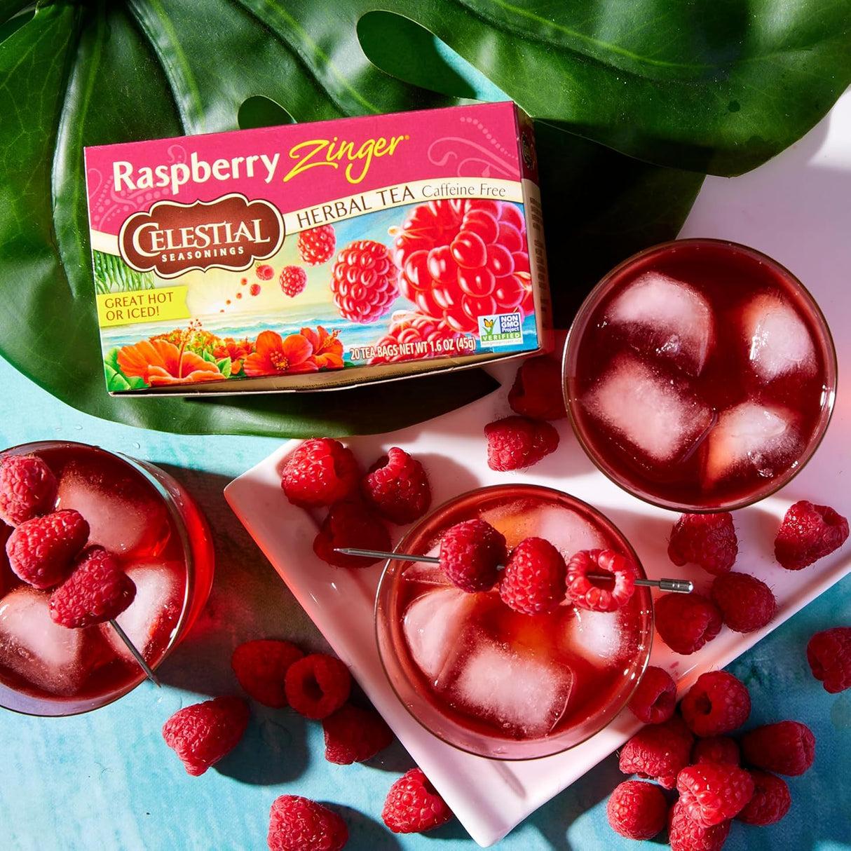 Celestial Seasonings Raspberry Zinger tea box with iced tea and raspberries on a colorful background