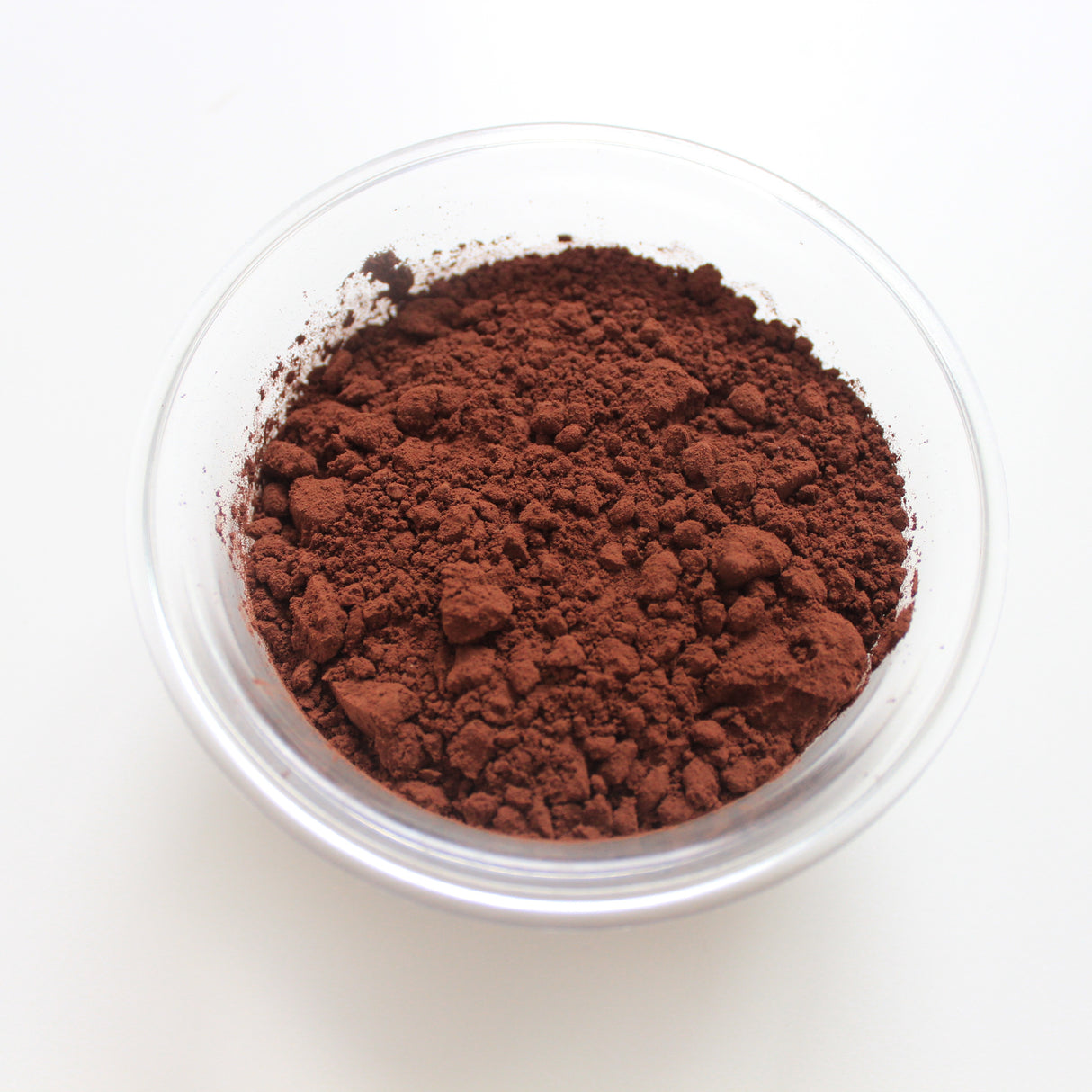 Cocoa powder in a clear container on a white background