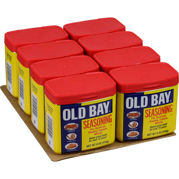 Old Bay seasoning containers with red lids on a cardboard tray