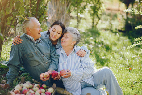 A family with two elderly parents and their daughter under a tree