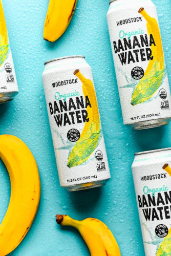 Woodstock Organic Banana Water cans with bananas on a blue background