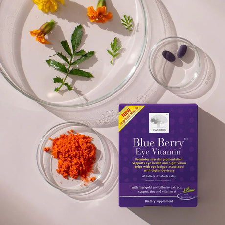 Blue Berry Eye Vitamin package with orange powder and flowers on a white background