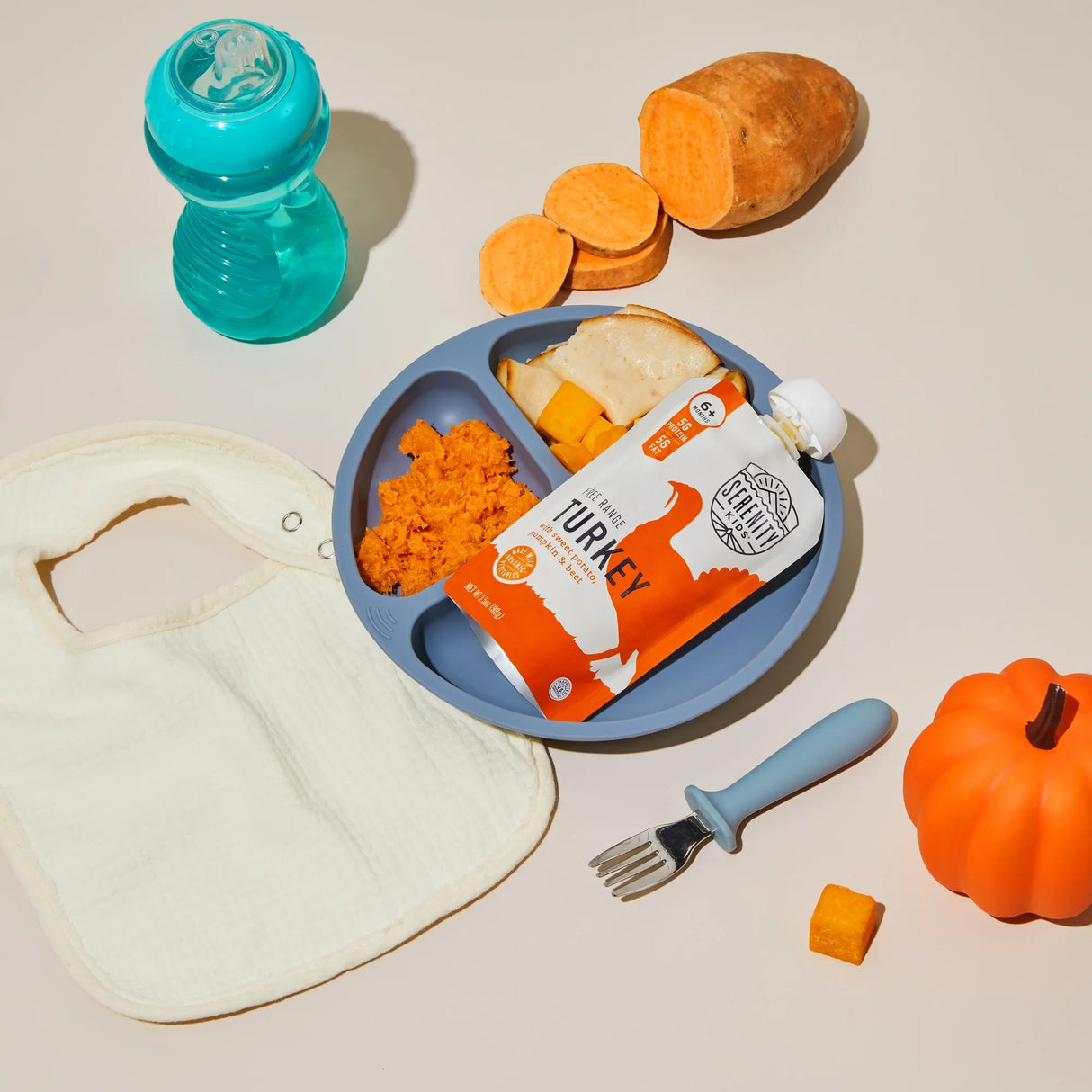 Children's meal set with plate, fork, and snack packaging on a beige background