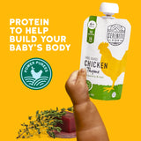 Serenity Kids free-range chicken thyme power puree packaging with a hand holding it against a yellow background.