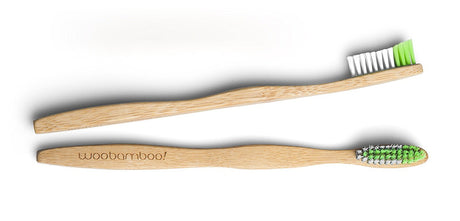 Two bamboo toothbrushes with green bristles on a white background