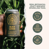 Hand holding a can of 'Black Lemon' sparkling botanical tea with brand details on a green leafy background.