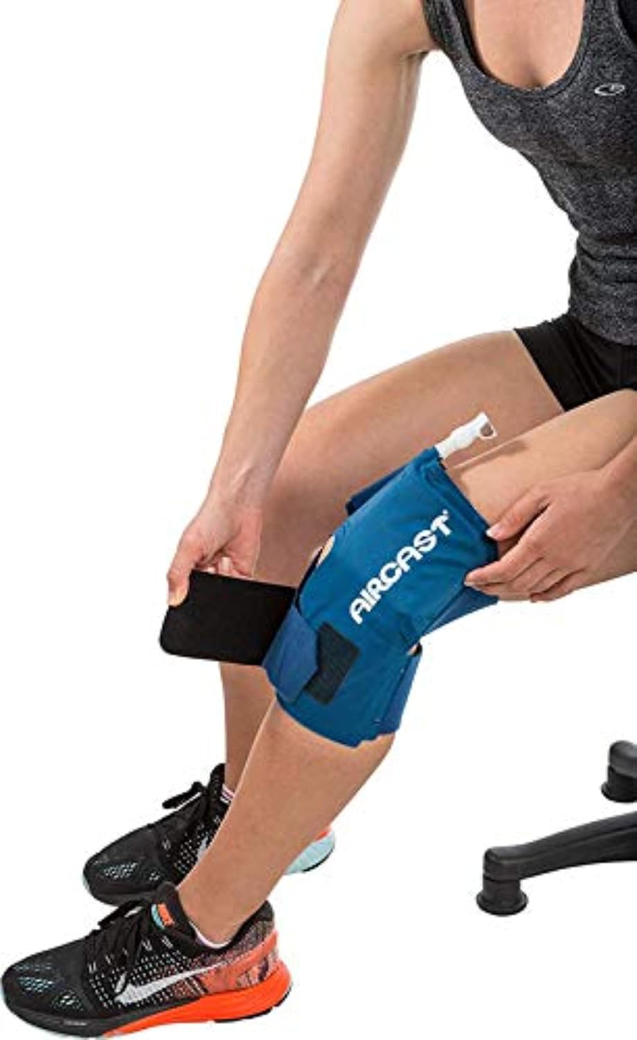 Person using a blue Aircast knee brace on a white background