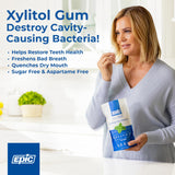 Woman holding a package of Epic Xylitol Gum with text about its benefits.