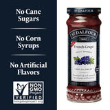 Jar of St. Dalfour strawberry fruit spread with health claims and Non-GMO Project verification on a blue background