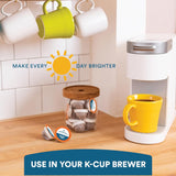 Yellow mug on a K-Cup Brewer with a jar of coffee pods and a sun graphic in the background.
