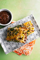 Pasta dish with a side of sauce on a patterned napkin