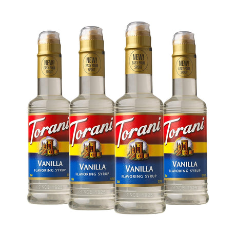 Four bottles of Torani Vanilla flavoring syrup on a white background