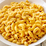 Macaroni and cheese in a white bowl on a wooden surface