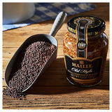 Maille whole grain dijon mustard jar with a scoop of mustard seeds on a wooden surface.