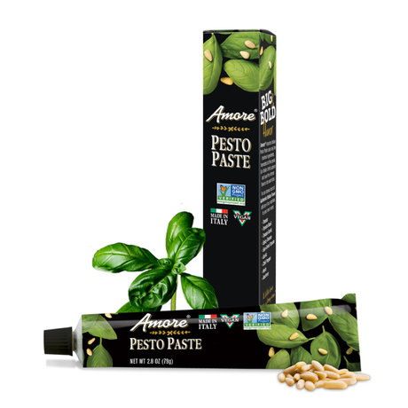 Amore Pesto Paste packaging with basil leaves and pine nuts on a white background