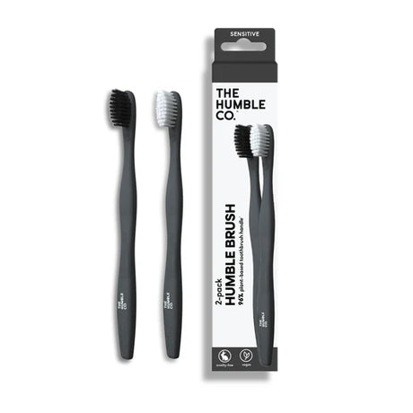 Two Humble co. toothbrushes with their packaging on a white background, featuring 'The Humble Co.' brand.