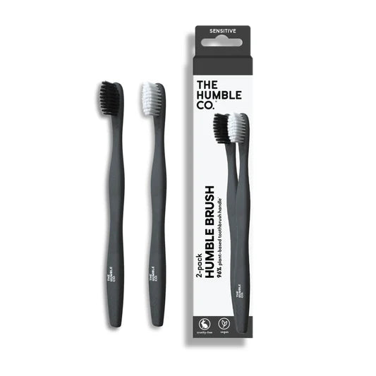 Two Humble co. toothbrushes with their packaging on a white background, featuring 'The Humble Co.' brand.