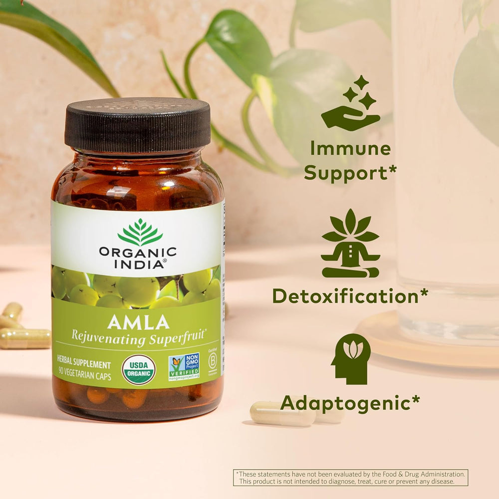 Bottle of Organic India Amla supplement with icons indicating immune support, detoxification, and adaptogenic properties on a light background.