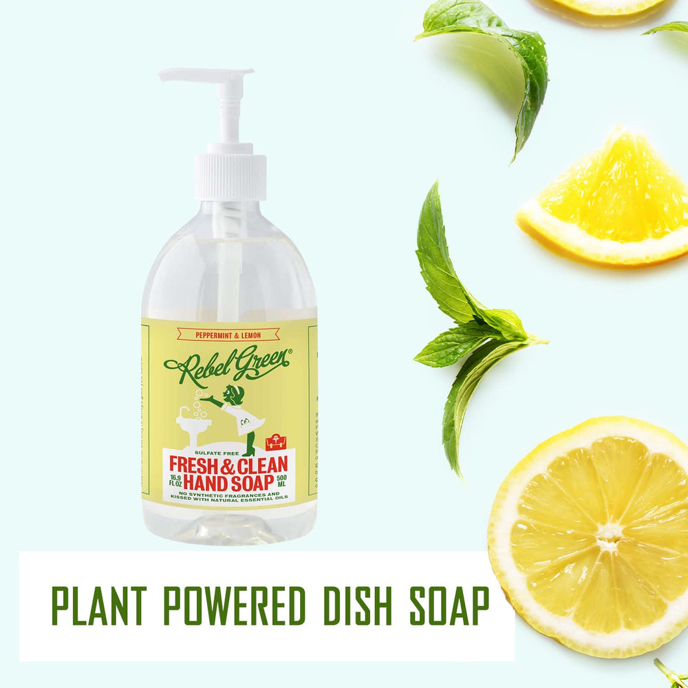Bottle of Rebel Green dish soap with lemons and mint leaves on a light background