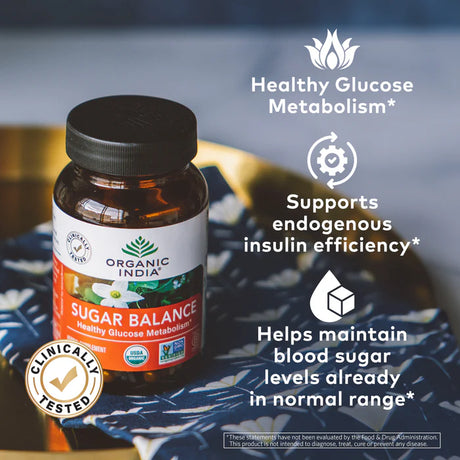 Bottle of Organic India Sugar Balance supplement on a textured surface with text highlighting benefits.