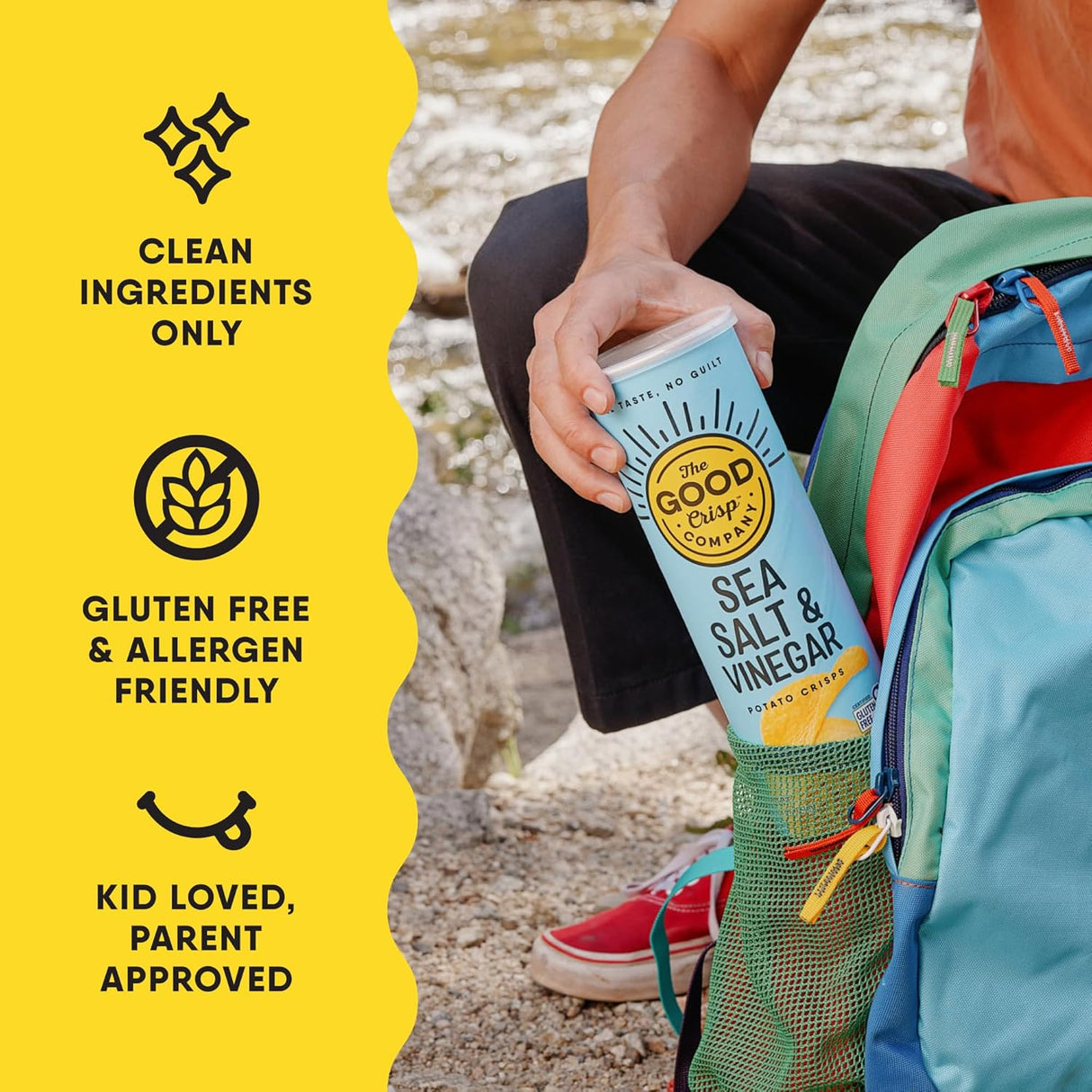Person holding a can of 'The Good Crisp' potato chips with product details on a yellow background.