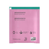 Pink stash tea bag packaging with green top on a white background