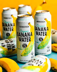 Cans of Woodstock Banana Water with bananas on a blue surface